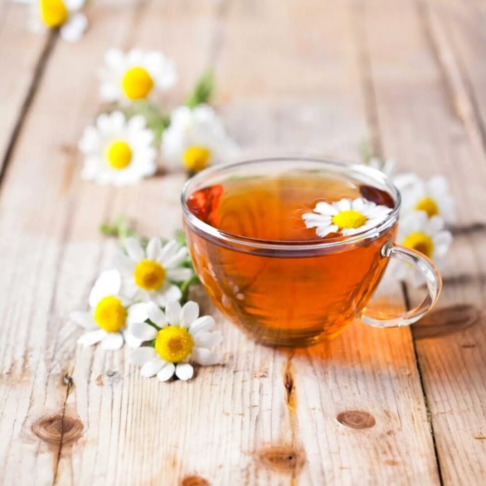 Dried chamomile flowers in a pouch and cup of herbal tea, organically grown and hand-packed in the hills of Himachal – calming, aromatic, and caffeine-free.