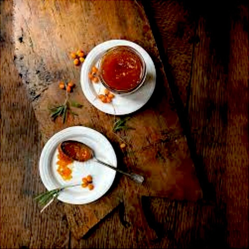 Homemade sea buckthorn jam in a glass jar, made from handpicked berries from the Himalayas, showcasing its rich golden-orange color and thick texture – a tangy, nutritious delight from Himachal Pradesh.