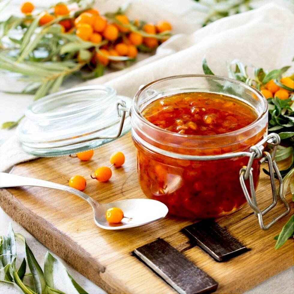 Homemade sea buckthorn jam in a glass jar, made from handpicked berries from the Himalayas, showcasing its rich golden-orange color and thick texture – a tangy, nutritious delight from Himachal Pradesh.