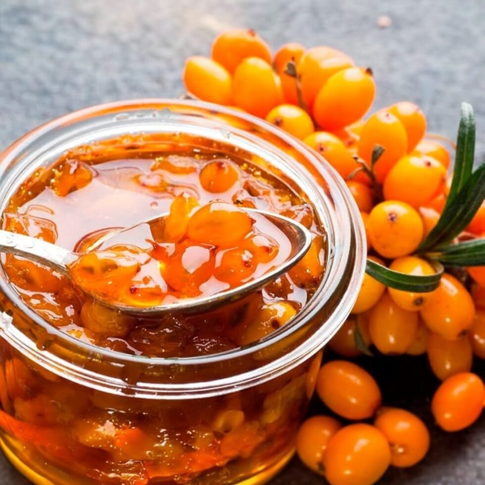 Homemade sea buckthorn jam in a glass jar, made from handpicked berries from the Himalayas, showcasing its rich golden-orange color and thick texture – a tangy, nutritious delight from Himachal Pradesh.