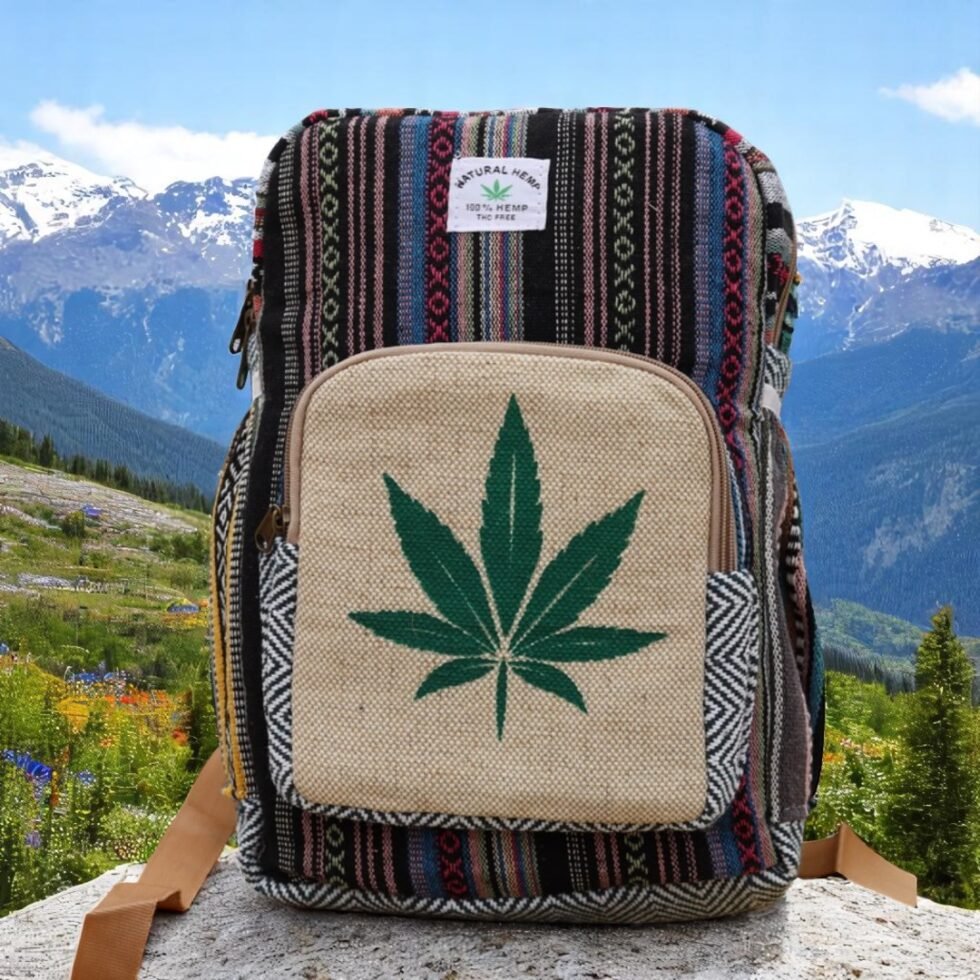 Handcrafted backpack made from cotton and hemp fabric with green hemp leaf print, featuring Himachali tribal design, placed on a rustic wooden table in the Himalayan outdoors