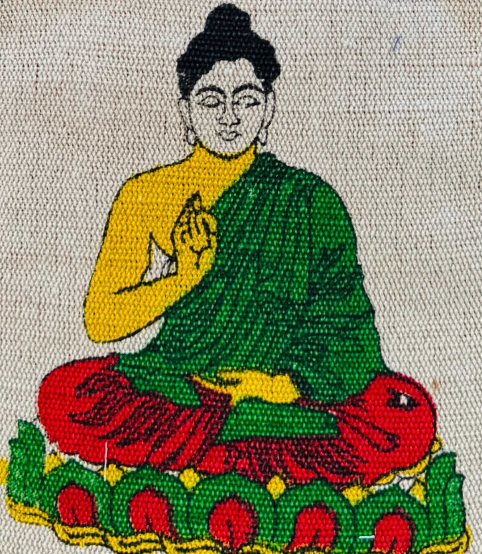 Handmade hemp and cotton backpack with Buddha art print, featuring tribal Himachali fabric details, placed in front of a natural mountain landscape from Kasol, Himachal